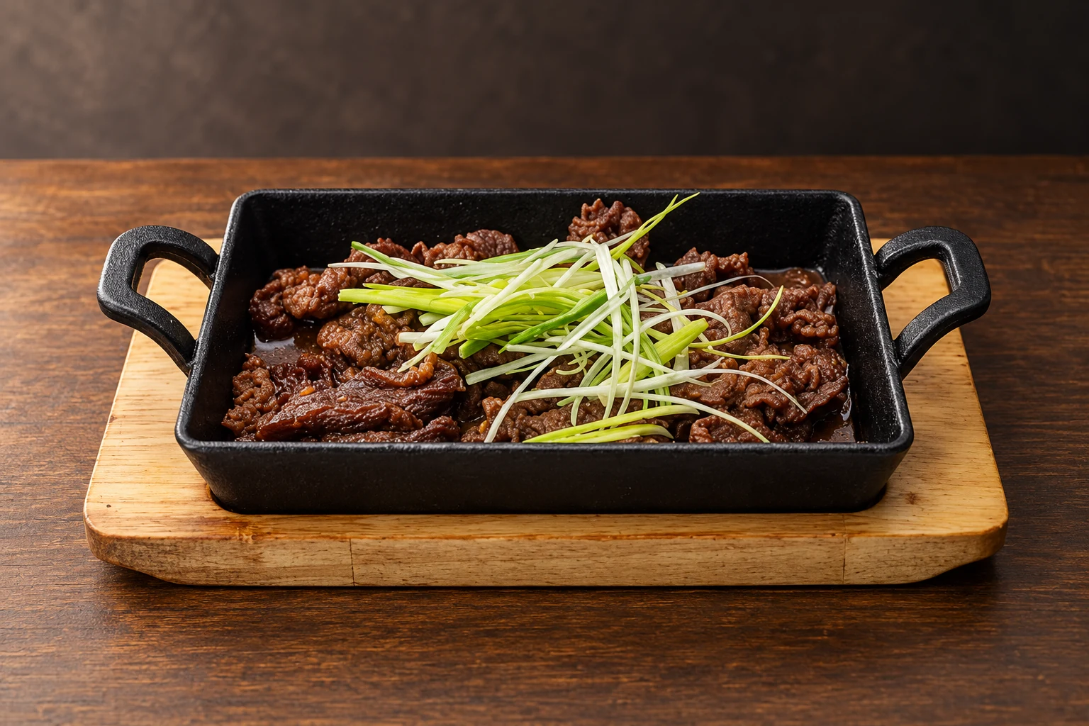 Bulgogi in a black rectangular dish on a wooden base