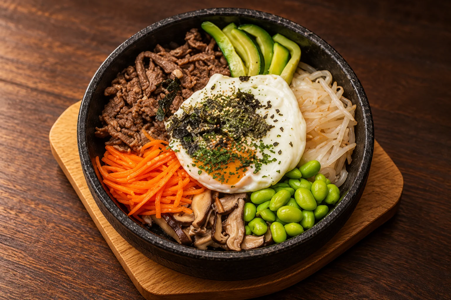 Bibimbap in a black bowl on a wooden table